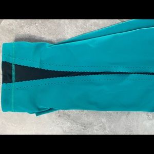 Adorable Lululemon size 4 teal & black crops with scalloped mesh side detail.